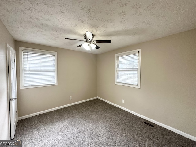 empty room with ceiling fan, a textured ceiling, and carpet