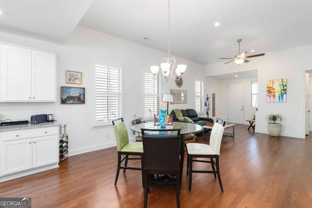 dining room featuring dark hardwood / wood-style floors and ceiling fan with notable chandelier