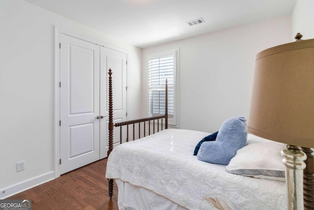 bedroom with dark hardwood / wood-style floors and a closet