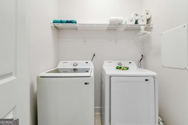 clothes washing area with washing machine and dryer