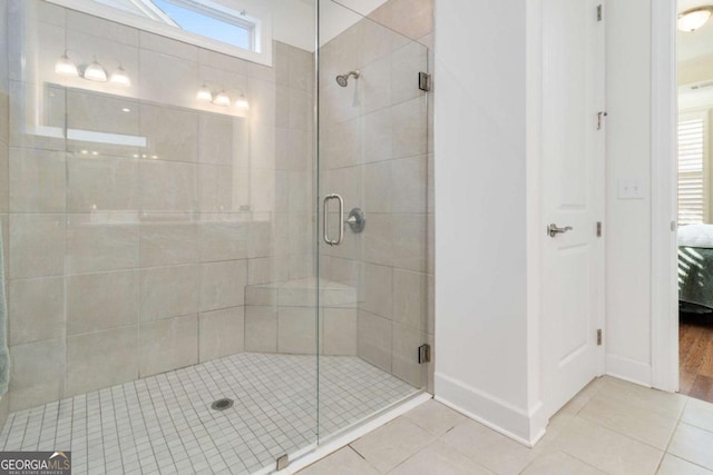 bathroom with a shower with door and tile patterned floors