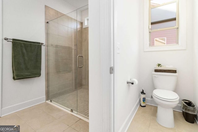 bathroom featuring a shower with shower door, tile patterned floors, and toilet