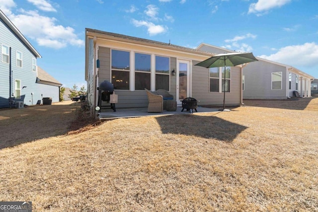 rear view of house with an outdoor fire pit, a yard, and a patio area