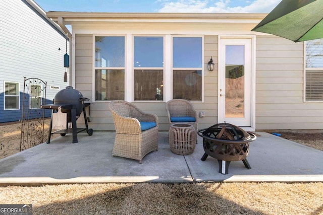 view of patio featuring an outdoor fire pit and a grill