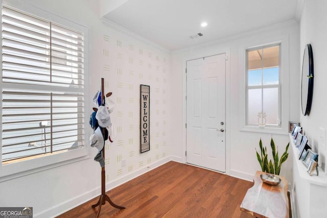 entryway with crown molding, dark wood-type flooring, and plenty of natural light