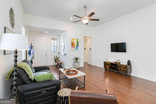 living room featuring dark wood-type flooring and ceiling fan