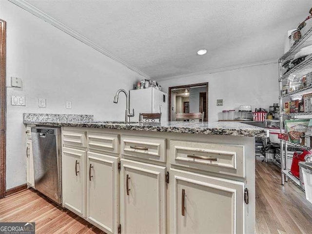 kitchen with sink, light stone counters, light wood-type flooring, ornamental molding, and dishwasher