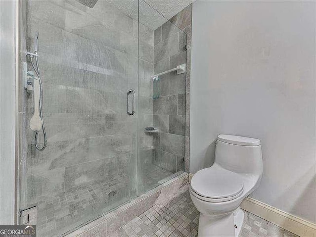 bathroom with walk in shower, tile patterned floors, and toilet