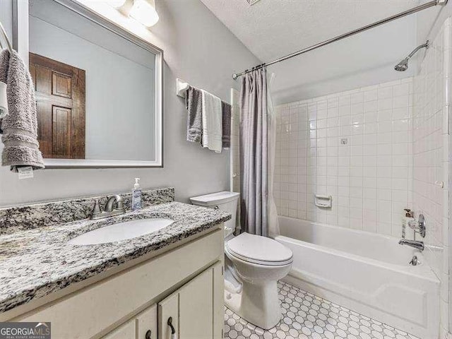 full bathroom featuring shower / bathtub combination with curtain, vanity, toilet, and a textured ceiling