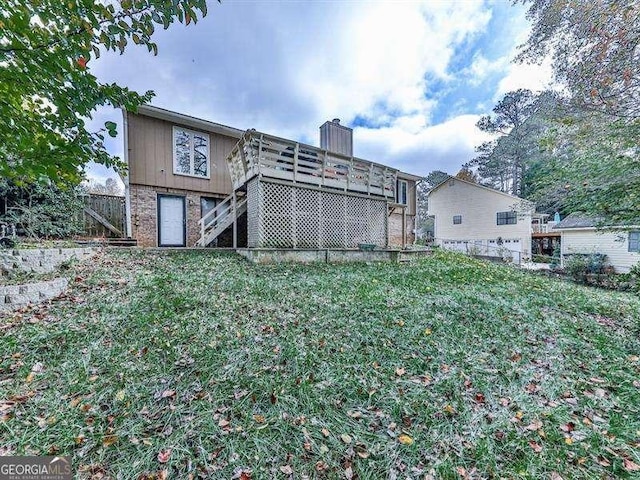 back of property featuring a wooden deck and a lawn