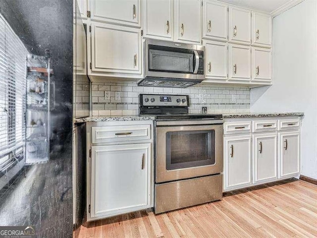 kitchen featuring backsplash, white cabinets, light hardwood / wood-style floors, stainless steel appliances, and light stone countertops