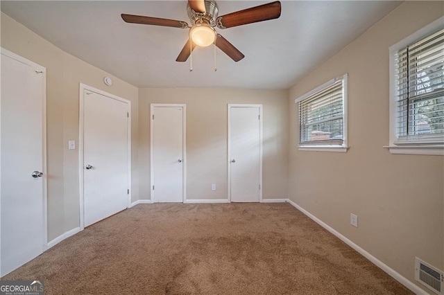 unfurnished bedroom with ceiling fan and carpet floors