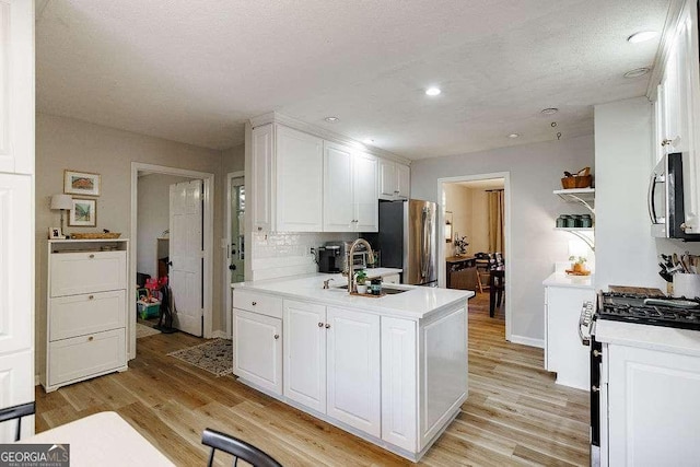 kitchen featuring sink, light hardwood / wood-style flooring, white cabinets, and appliances with stainless steel finishes