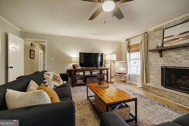 living room with crown molding, a fireplace, a textured ceiling, and hardwood / wood-style flooring