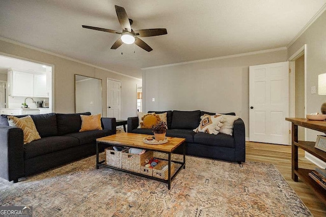 living room with crown molding, hardwood / wood-style flooring, and ceiling fan