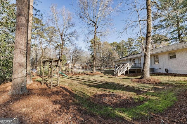 view of yard with a wooden deck and a playground