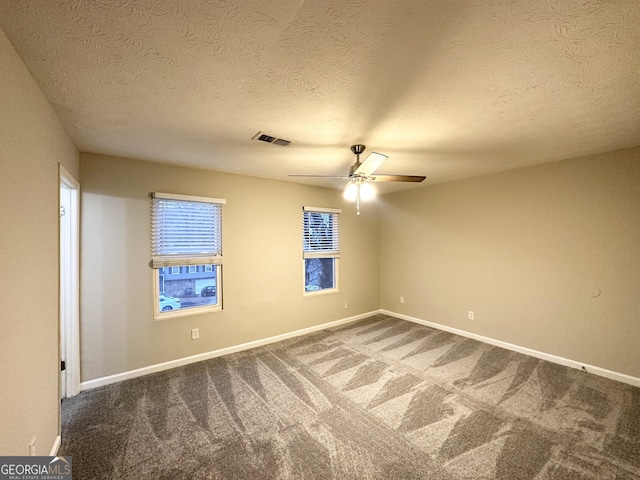 carpeted spare room featuring ceiling fan and a textured ceiling