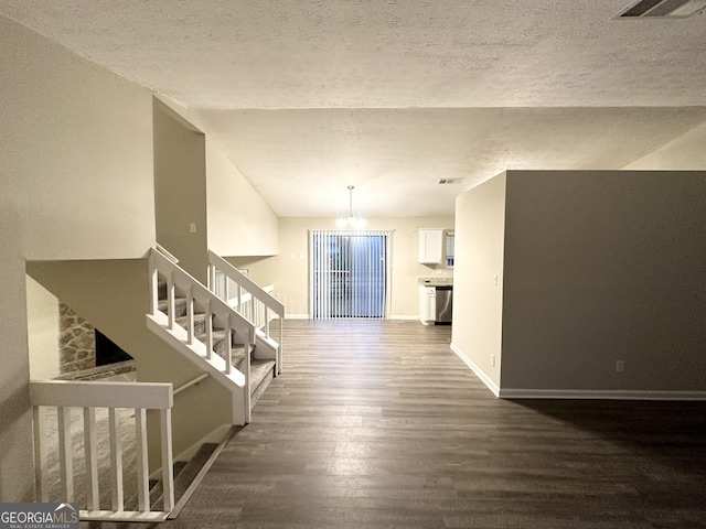 interior space with dark hardwood / wood-style floors, a notable chandelier, and a textured ceiling