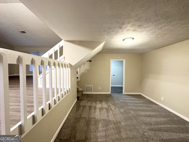 additional living space featuring carpet flooring and a textured ceiling