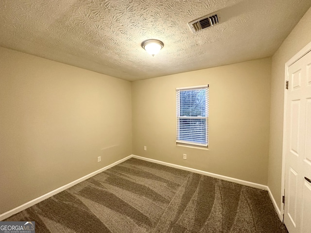 carpeted empty room with a textured ceiling