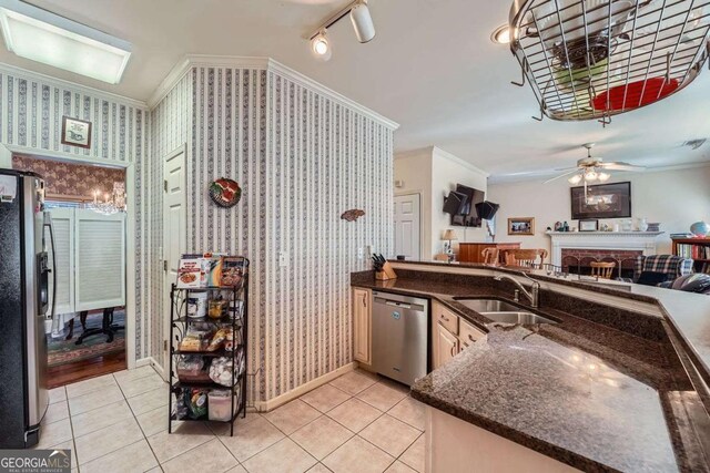 kitchen with sink, ornamental molding, stainless steel appliances, and light tile patterned flooring