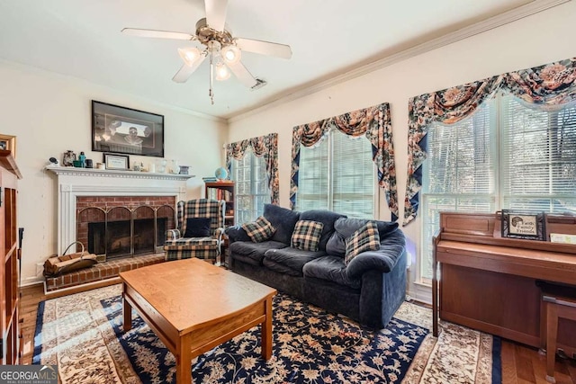 living room featuring hardwood / wood-style flooring, crown molding, a brick fireplace, and ceiling fan