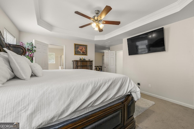 carpeted bedroom with crown molding, ceiling fan, and a tray ceiling