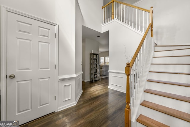 foyer entrance with dark hardwood / wood-style flooring and a high ceiling