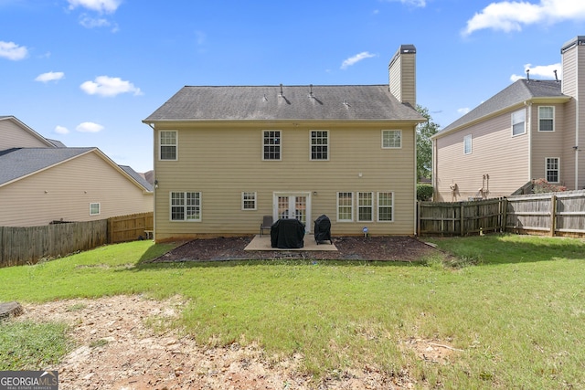 rear view of property featuring a patio area and a lawn