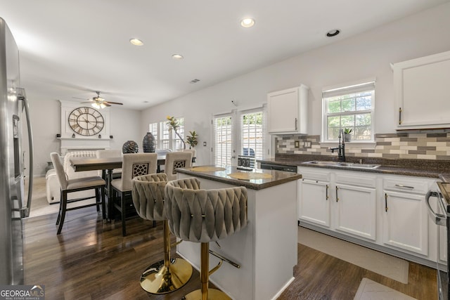 kitchen featuring stainless steel refrigerator, sink, tasteful backsplash, and white cabinets