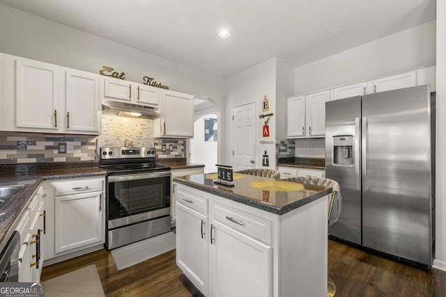 kitchen with dark wood-type flooring, stainless steel appliances, a center island, and white cabinets