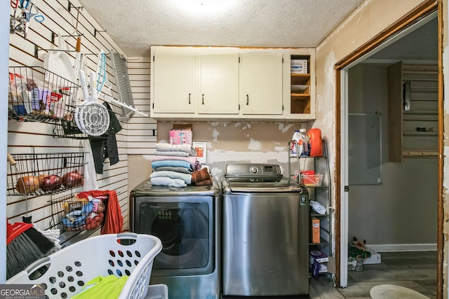 laundry room featuring separate washer and dryer, hardwood / wood-style flooring, cabinets, and a textured ceiling