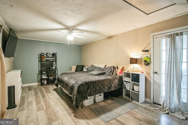 bedroom with crown molding, ceiling fan, light hardwood / wood-style floors, and a textured ceiling