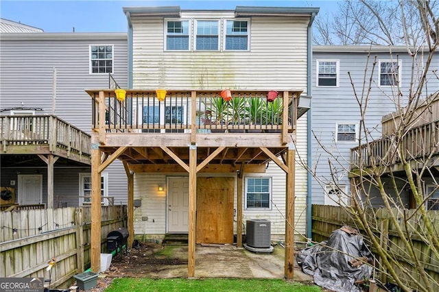 rear view of house featuring a wooden deck and central AC unit