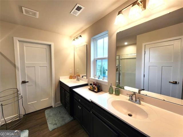 bathroom with wood-type flooring, an enclosed shower, and vanity