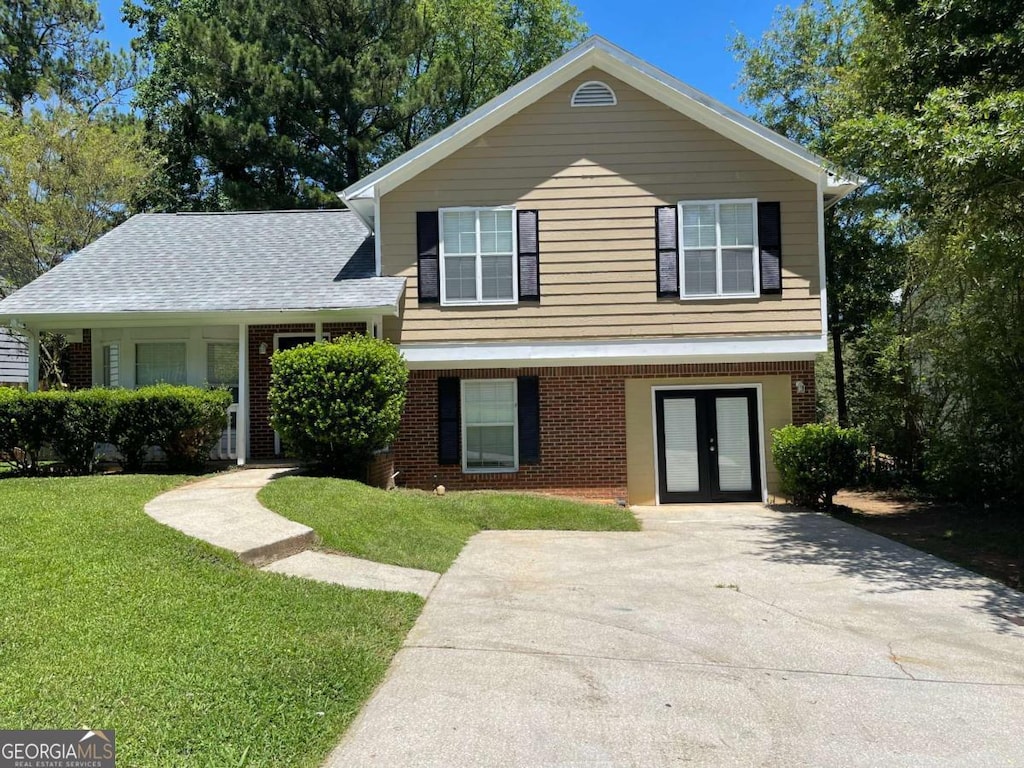 split level home featuring a front yard and french doors