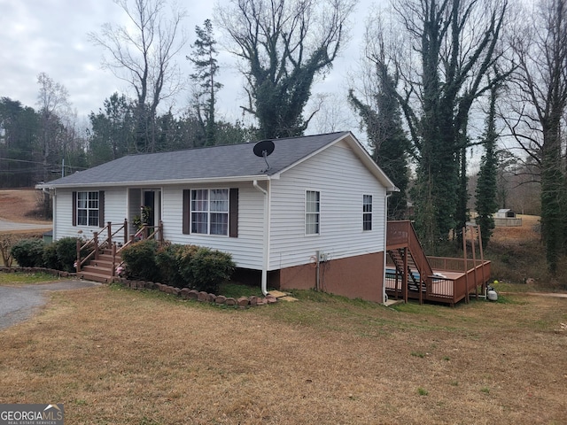 view of front of home with a wooden deck and a front lawn