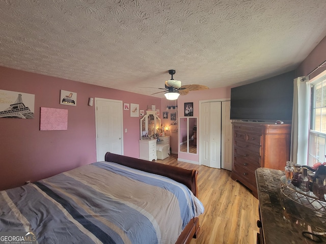 bedroom with a textured ceiling, light wood-style floors, a closet, and ceiling fan