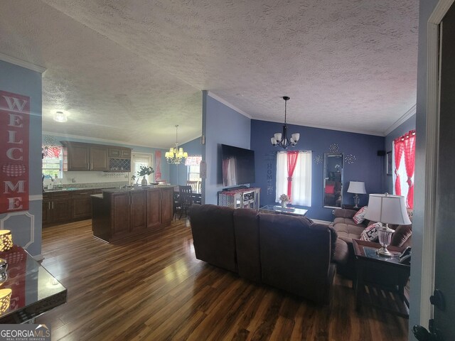 living room featuring lofted ceiling, dark hardwood / wood-style floors, sink, and a notable chandelier