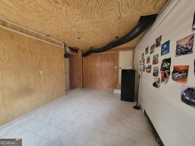 interior space featuring wooden ceiling and wood walls