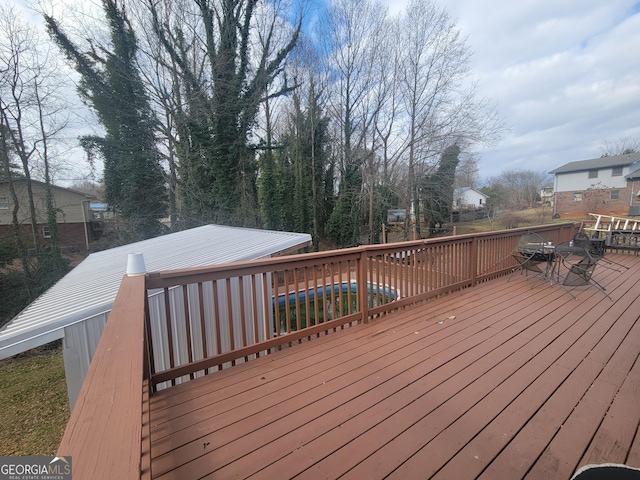 wooden deck featuring a covered pool and outdoor dining area