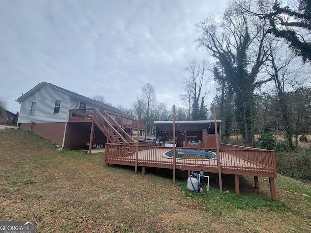 rear view of house featuring a yard, stairway, and a deck