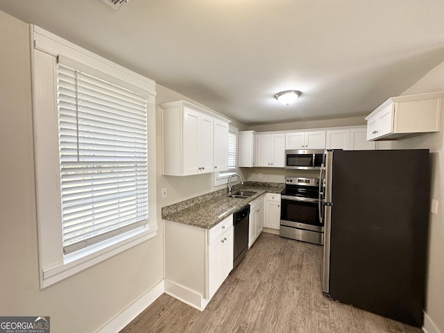 kitchen with white cabinetry, sink, light hardwood / wood-style floors, and appliances with stainless steel finishes