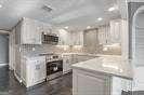 kitchen featuring light stone counters and white cabinets