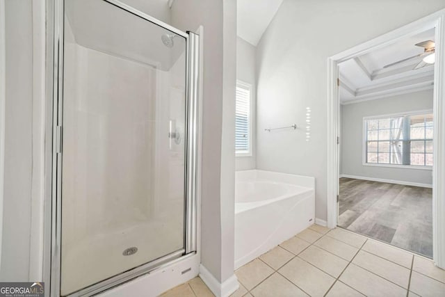 bathroom featuring plus walk in shower, ornamental molding, ceiling fan, a tray ceiling, and tile patterned floors