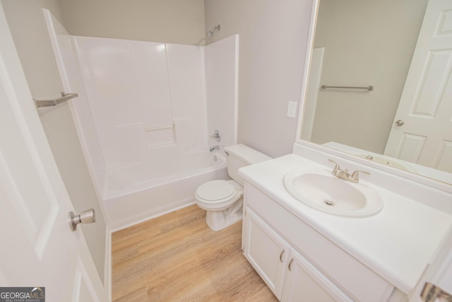 full bathroom with hardwood / wood-style flooring, vanity, washtub / shower combination, and toilet