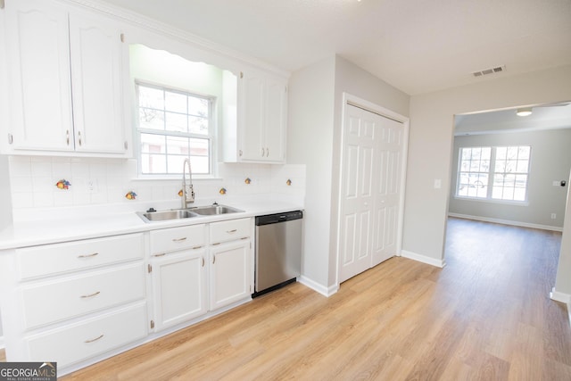 kitchen with white cabinetry, sink, stainless steel dishwasher, and light wood-type flooring