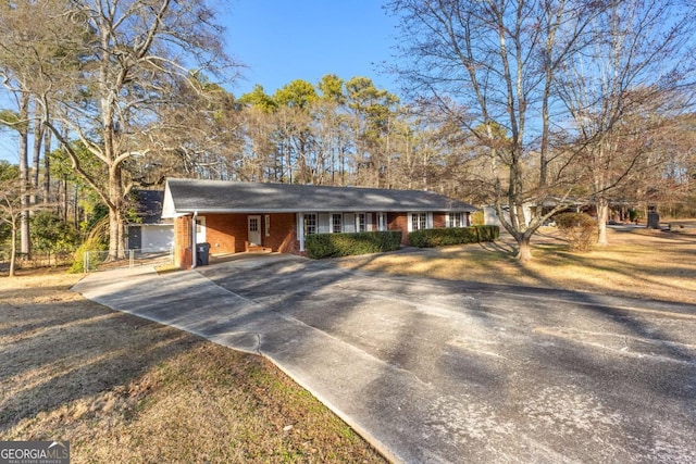 ranch-style house featuring brick siding, a carport, and concrete driveway