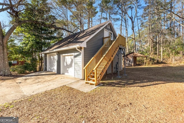 view of home's exterior featuring a detached garage and stairway