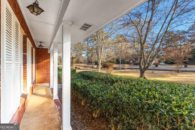 view of yard with a porch and visible vents